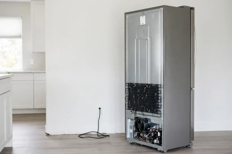Back of a refrigerator showing condenser coils and fan unit